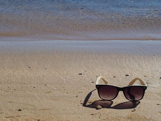 Sunglasses on a sandy beach Copy space