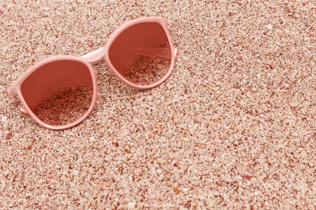 Sunglasses on sandy beach with copy space