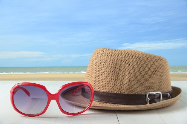 Photo sunglasses and sun hat on table at beach against sky