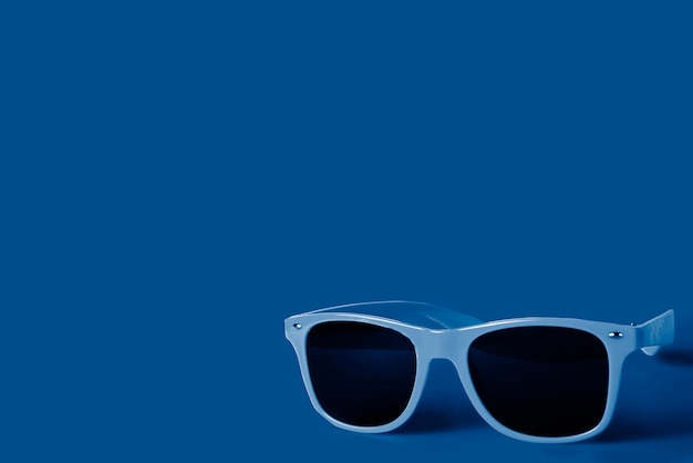 トレンディなクラシックブルーの色合いのサングラス。コピースペース
