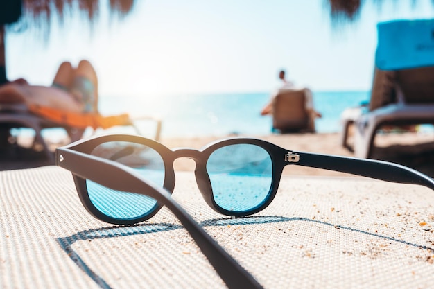 Sunglasses of a tourist on a deckchair at a beach