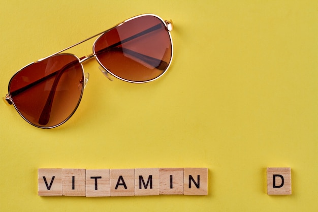 Sunglasses and vitamin d made of wooden blocks.