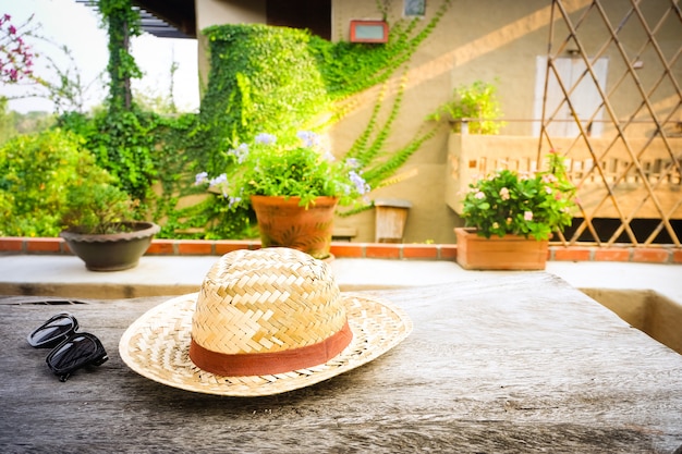 Foto occhiali da sole con cappello di paglia vintage fasion sul tavolo di legno