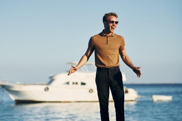 In sunglasses Young man is outdoors at sunny daytime Concept of vacation