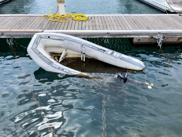 Sunken inflatable boat near a wooden pier