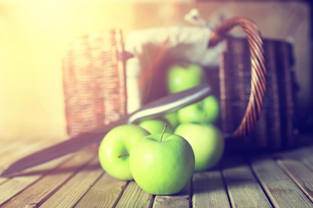 Sunlight green apple in a basket wooden background