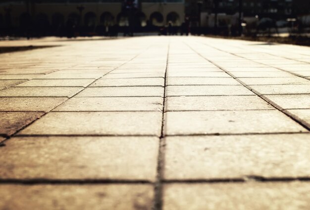 Sunlight on paved cobblestone pavement