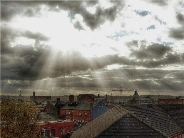 Foto la luce del sole che scorre attraverso le nuvole sopra la città