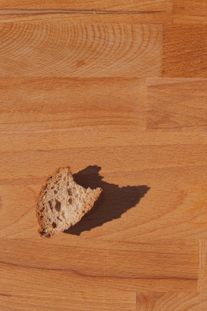 写真 木製の背景に太陽に照らされたパン片