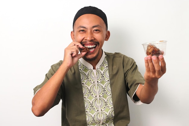 Foto alimentazione sunnah uomo indonesiano si diverte con i datteri durante l'iftar