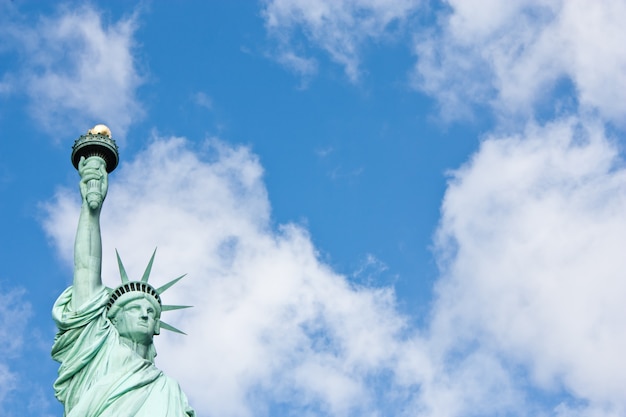 Sunnny day, blue sky with clouds: statue of Liberty with copy space