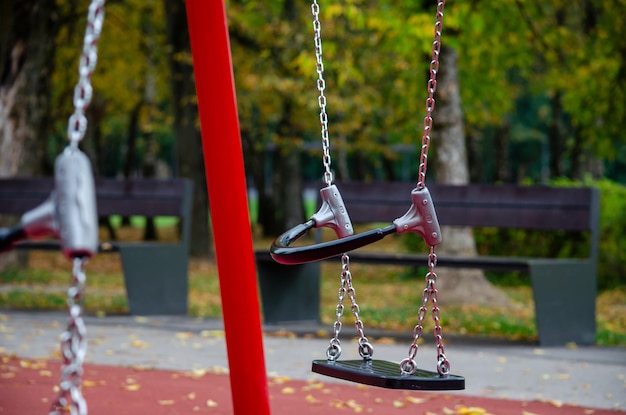 On a sunny autumn day the childrens swing is empty on the playground