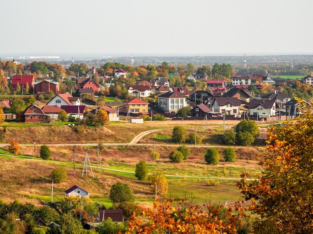 Фото Солнечный осенний сельский пейзаж с домами на расстоянии. россия.