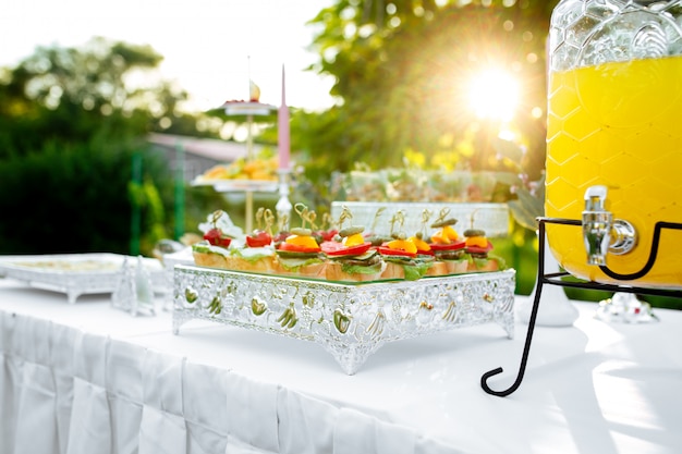 Photo sunny banquet table tappas canape and lemonade jar