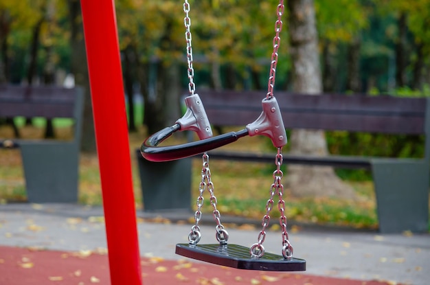 On a sunny day the childrens swing is empty on the playground