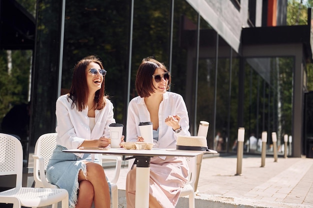 At sunny daytime two female friends have great weekend outdoors\
together