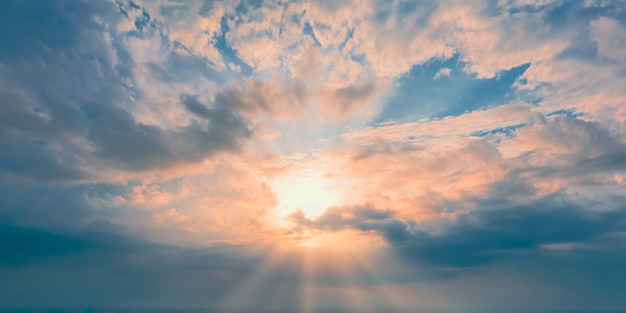 地平線の晴れた夕方の太陽と青い空の黄色い雲