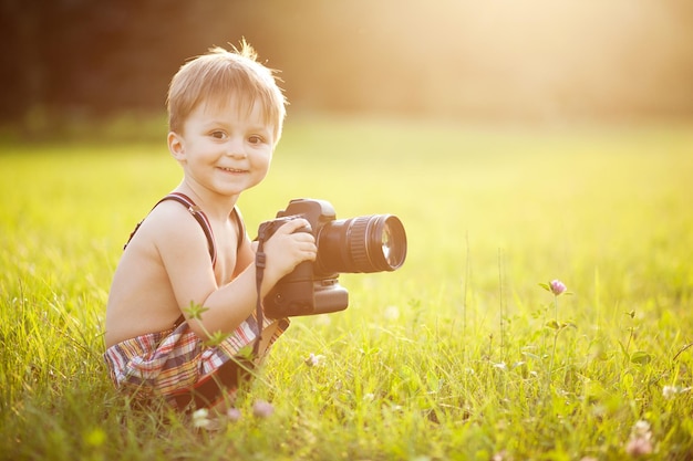 カメラを持つ子供の日当たりの良い肖像画