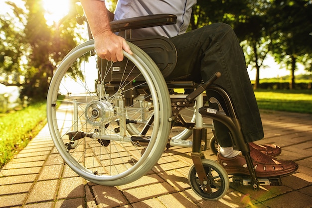 Photo sunny road  wheel of wheelchair  close up