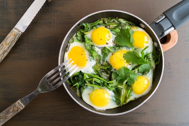 Sunny side up egg with spinach. in a pan.