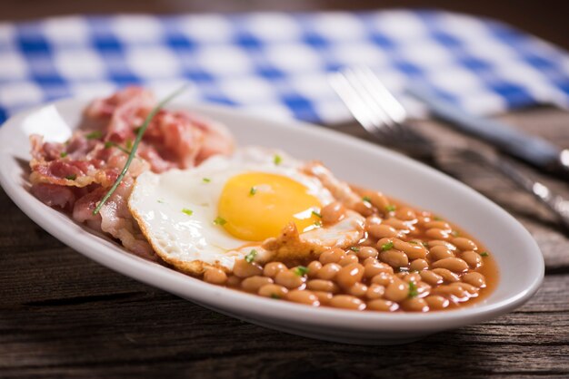 Uova al tegamino con bacon biologico, hashbrown e crostini croccanti