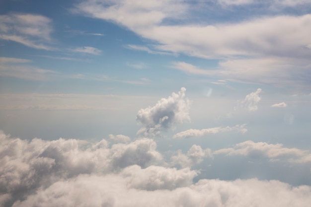 Fondo astratto del cielo soleggiato, bello cloudscape, sul cielo, vista sopra le nuvole lanuginose bianche, concetto di libertà