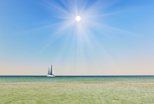 Sunny sky against the backdrop of the sea with a sailboat