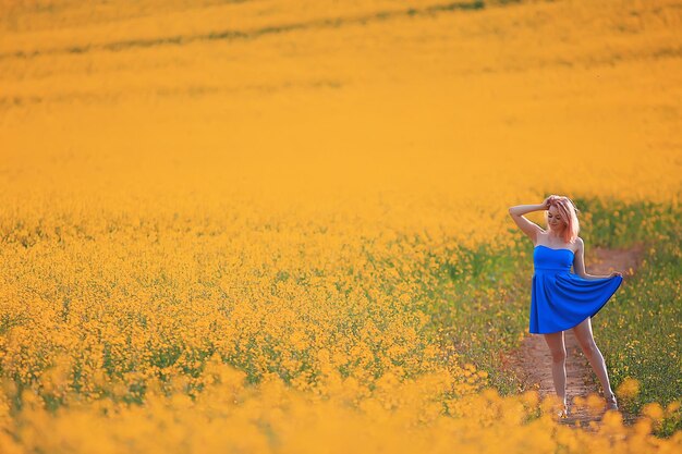 Sunny summer in the field girl in a dress, beautiful young woman enjoys a dream