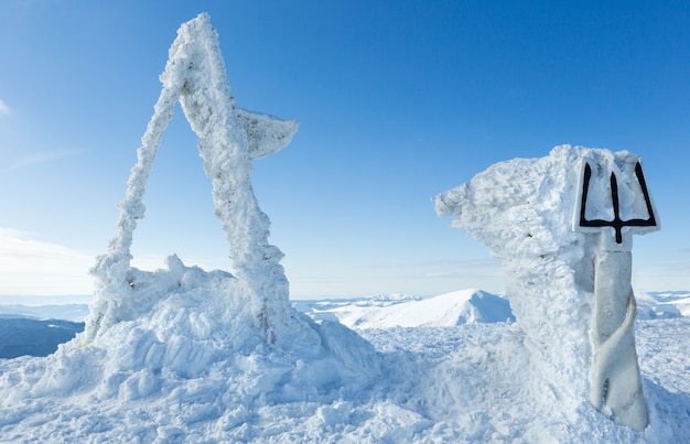 Soleggiato inverno goverla mount top con monumento scultoreo innevato a tryzub ucraino (carpazi, ucraina).