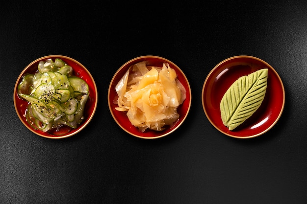 Sunomono, ginger and wasabi isolated on black background. top view.