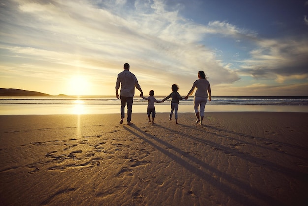 Sunrise beach and back of family holding hands and walking on holiday summer vacation and weekend Nature travel and mother father and children by ocean for bonding adventure and quality time