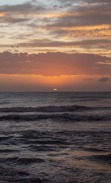 Photo sunrise on the beach with colorful clouds