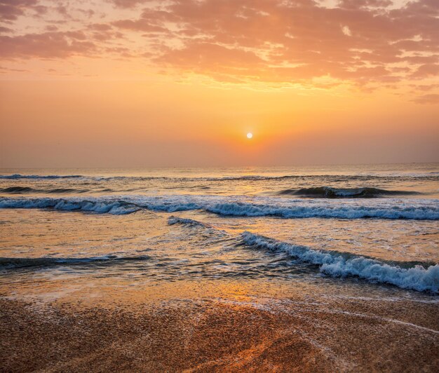 Sunrise on beach with dramatic sky