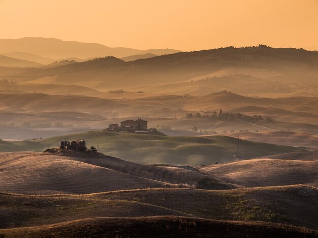 Photo sunrise over farms in hilly countryside in tuscany italy