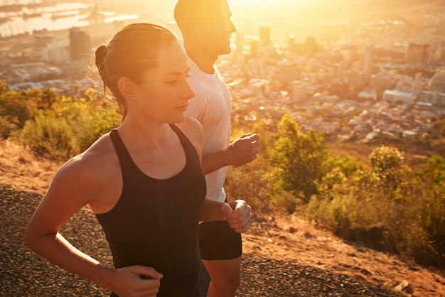 Sunrise fitness en personal trainer training vrouw als training of ochtendoefening voor gezondheid en welzijn Sportmarathon en hardloper rennen met mannelijke atleet in een stad voor sport en energie