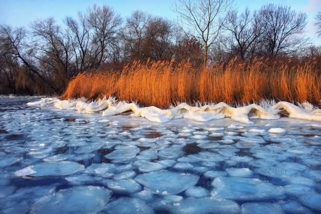 Sunrise and frozen sea. Beautiful winter landscape with lake in morning time.