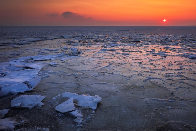 Sunrise and frozen sea. Beautiful winter landscape with lake in morning time.