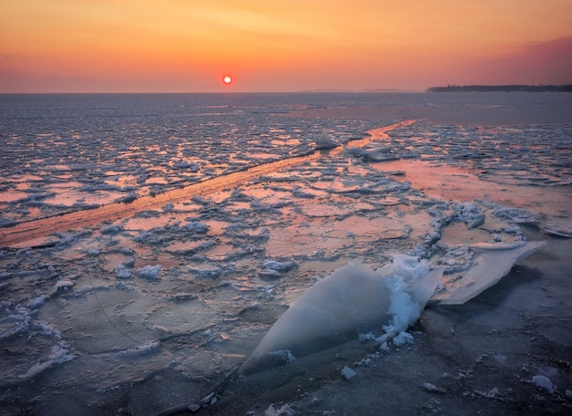 Alba e mare ghiacciato bellissimo paesaggio invernale con lago e sole rosso al mattino alba