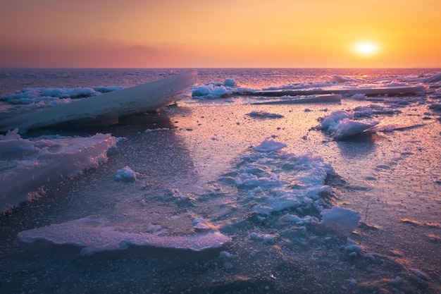 Sunrise and frozen sea Beautiful winter landscape with lake and red sun in morning time Daybreak