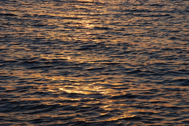 Sunrise is reflected in the waves on the sea