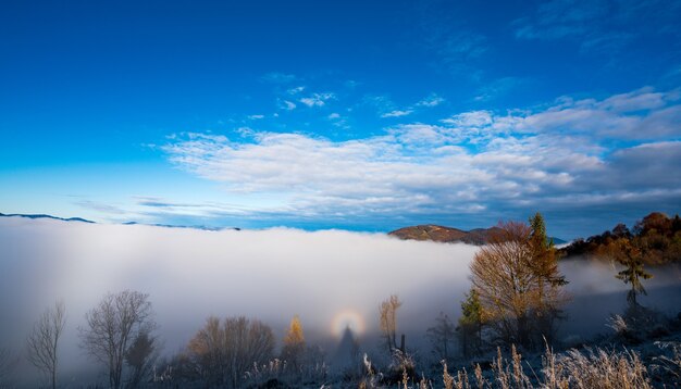 Sunrise over mountain hils covered with gray mist.