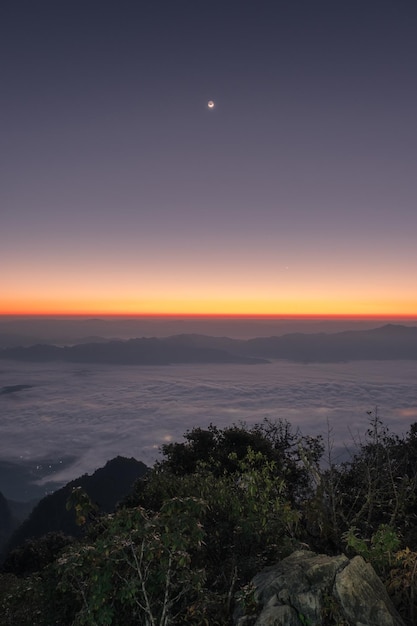 Sunrise on mountain range with foggy and the moon