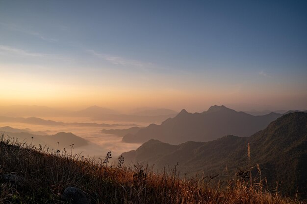 霧と雲がそれを覆っている山の日の出