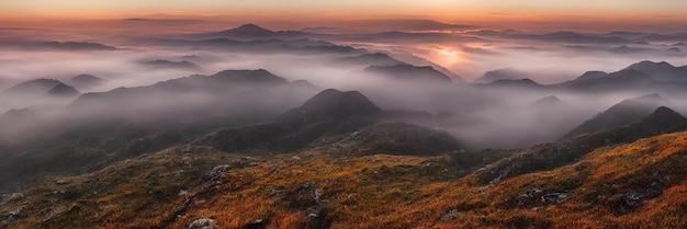 Sunrise in the mountains beautiful landscape Morning fog flows down the slopes of the mountains Panorama of mountain peaks and ridges 3d illustration