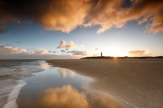 Photo sunrise on north sea coast with lighthouse