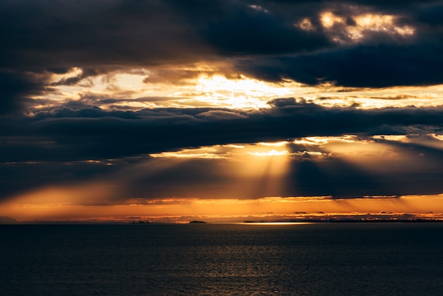 Sunrise on river. Sunbeams make a way through the clouds