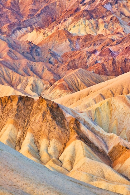 Sunrise showcases layers of stunning colors in eroded sediment at death valley