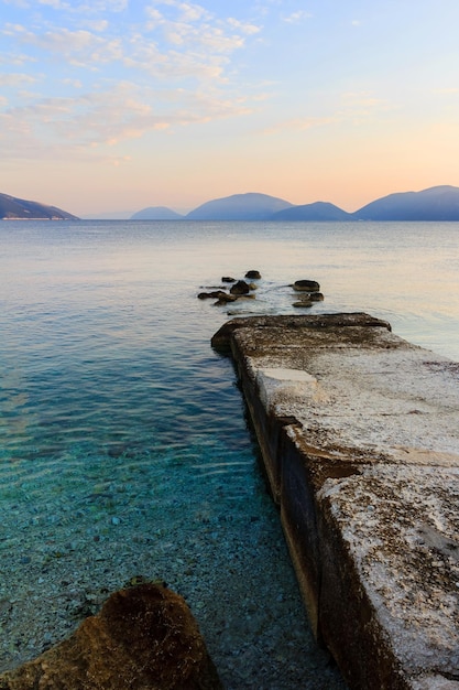 Sunrise in a small bay with old pier. mediterranean sea