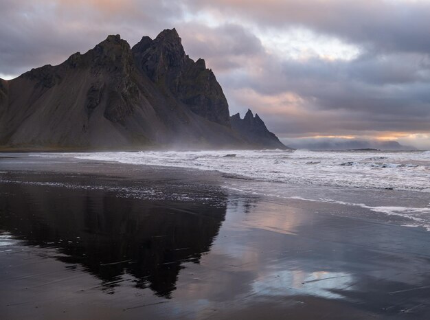 일출 Stokksnes 케이프 바다 해변과 젖은 검은 화산 모래 표면에 반사된 베스트라호른 산 아이슬란드 놀라운 자연 풍경 인기 여행지