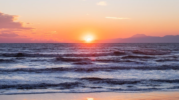 美しい地平線と海に沈む日の出と日の入り自然の驚異冬の海の美しい風景